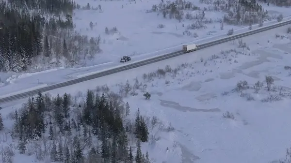 ノルウェーのロフォンテ諸島とトロムソ間の道路は雪に覆われ 雪の除雪車が動いていて 日没の色が山に当たっています — ストック写真
