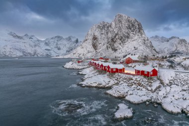 Norveç Lofoten Adaları Kış mevsimi karla kaplı sahiller bulutlu gökyüzü ve renkli evler