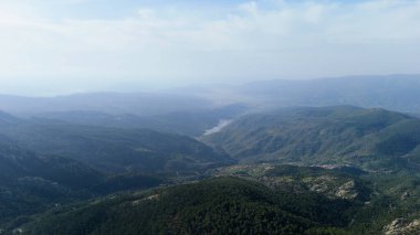 Ormanda yol ve dağlardan gelen bulutlu gökyüzü, uzak bir mesafeden mugla koycegiz gölü manzarası