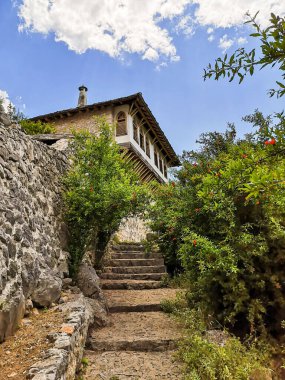 Yeşil ve mavi gökyüzü ve beyaz bulutları olan eski bir ev.