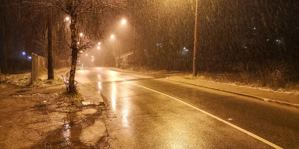 Neve Cai Escuro Uma Estrada Molhada Sob Uma Lâmpada Rua — Fotografia de Stock