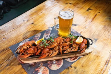 Haşlanmış kerevit, limon, dereotu ve otlar mavi ahşap arka planda ahşap bir kesme tahtasında. Kerevit yemeği. Bira partisi. Yüksek kalite fotoğraf