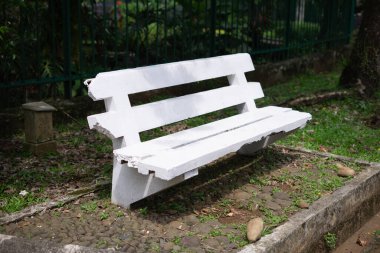 Çimentodan yapılmış bahçe tezgahı ve Endonezya 'daki botanik bahçesindeki büyük bir ağacın altına beyaza boyanmış.