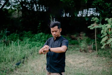 Saate bakan adam avluda poz veriyor.