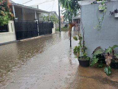 Şiddetli yağmurlar nedeniyle sel basmış bir yerleşim bölgesinde bir yol.
