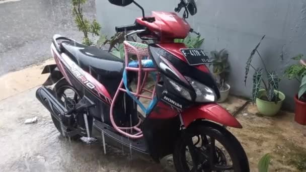 在房子的停车场里暴露在雨水中的自动摩托车 — 图库视频影像