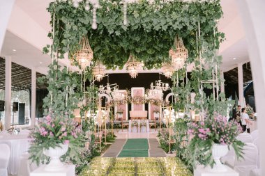 Düğün salonunu geleneksel düğün teması ile süslemek güzel yapraklar ve çiçeklerle süslenir.