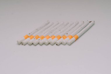 Beyaz bir üste dizilmiş birkaç kretek sigarası.