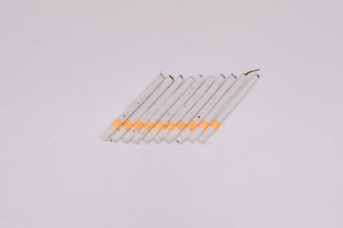 Beyaz bir üste dizilmiş birkaç kretek sigarası.