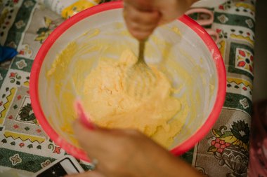 Tereyağı, yumurta, buğday unu ve şeker unu karışımı. Bu hamur, bayram pastası yapmaya hazır..