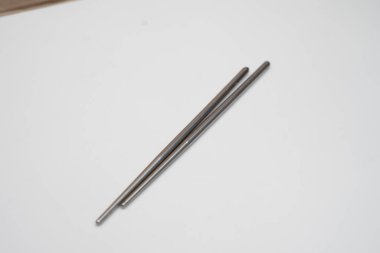 Beyaz bir tabana yerleştirilmiş yemek çubuğu.