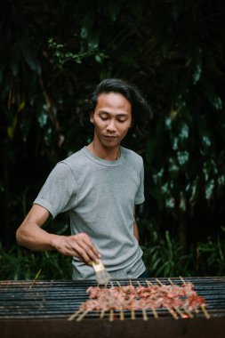 Yetişkin bir adam sigara yakıyor.