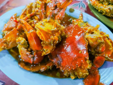 Lezzetli bir tabak Padang usulü soslu yengeç, mükemmel pişmiş ve zevk almaya hazır, Endonezya mutfağı lezzeti sergileniyor..