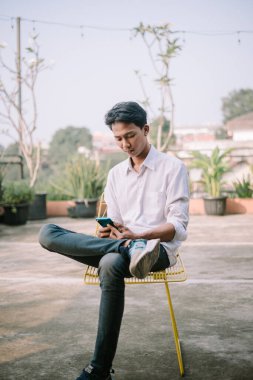 Bir insan, akıllı telefonunda eşinden gelen ayrılık mesajını okurken üzgün görünür.