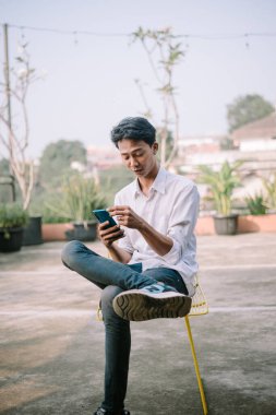 Akıllı telefonundan üzücü haberler alan bir adam şok olmuş gibi görünür.