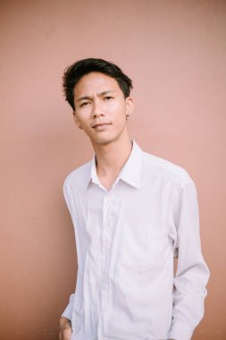 Tarafsız bir yüz ifadesi olan bir adam, basit ama büyüleyici bir görüntüde sakin ve iç gözlem duygusunu somutlaştırıyor..