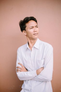 Yüzünde düz bir ifade olan bir adam kol hareketi yapıyor.