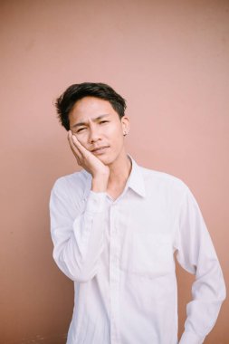 Yanağını tutan bir adam, görünen o ki diş ağrısından dolayı acı çekiyor.