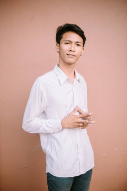 Bir adam keskin bir bakışla parmaklarını kavuşturuyor, konsantrasyon yayıyor ya da belki bir azim ve odaklanma hareketi sergiliyor..