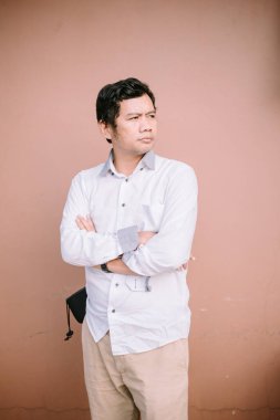 Tarafsız bir yüz ifadesi olan bir adam, basit ama büyüleyici bir görüntüde sakin ve iç gözlem duygusunu somutlaştırıyor.