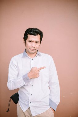 Solu gösteren, yönü belirten ya da kamera dışı bir şeye dikkat çeken bir adam..