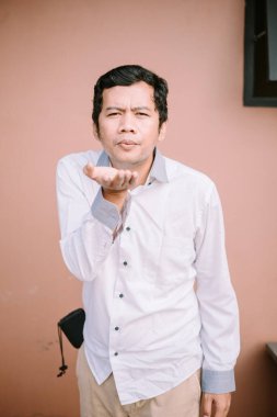 Nazikçe bir şey üfleyen bir adam, odaklanmış bir anı yakalıyor.