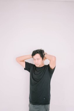 Kafasını tutan Güneydoğu Asyalı bir adam, muhtemelen derin düşünce ya da strese işaret ediyor. Yüzündeki ifade, pazarlama veya editoryal kullanımda çeşitli duygusal bağlamlar için uygun çok yönlü bir görüntü sağlar.