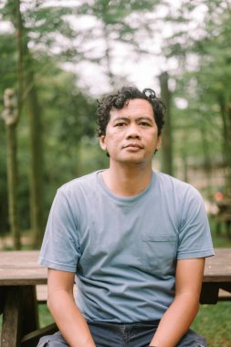 Boş bakışları olan Asyalı bir adam, tefekkür ya da boşluğun ifadesini yakalıyor, duygusal olarak mükemmel.