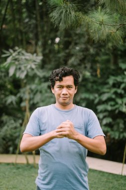 Güneydoğu Asyalı bir adam dövüşmeye hazır yumruklarını sıkıyor. Gerginlik ve kararlılık anı yakalıyor.