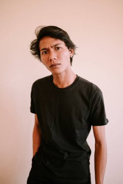 Güneydoğu Asyalı bir adam kaşlarını çatmış, sıradan giyinmiş. İfadesi konsantrasyon, endişe ya da derin düşünce iletir. Düşünce ve duygu teması için mükemmeldir.