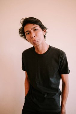 Güneydoğu Asyalı bir adam kaşlarını çatmış, sıradan giyinmiş. İfadesi konsantrasyon, endişe ya da derin düşünce iletir. Düşünce ve duygu teması için mükemmeldir.