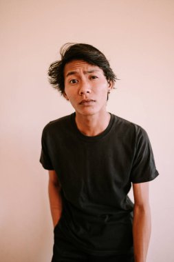 Kafası karışmış bir ifadeyle ileriye bakan Güneydoğu Asyalı bir adam, belirsizlik anını yakalıyor, duygusal, portre ve yaşam tarzı projeleri için mükemmel.