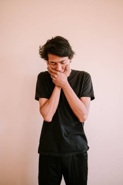 İki eliyle ağzını kapatan Güneydoğu Asyalı bir adam, sürpriz ya da şok anını yakalıyor, duygusal, portre ve yaşam tarzı projeleri için mükemmel..