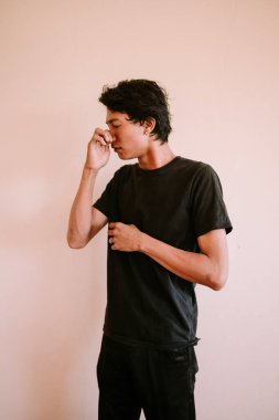 Burnunu tutan Güneydoğu Asyalı bir adam, kötü bir kokuya bir anlık rahatsızlık ya da tepki yakalıyor, duygusal, portre ve yaşam tarzı projeleri için mükemmel.