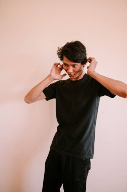 İki kulağını da kaplayan Güneydoğu Asyalı bir adam, bir anlık gürültü önleme veya hayal kırıklığı yakalıyor, duygusal, portre ve yaşam tarzı projeleri için mükemmel.