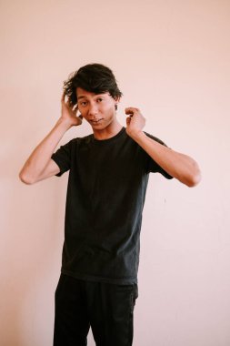 İki kulağını da kaplayan Güneydoğu Asyalı bir adam, bir anlık gürültü önleme veya hayal kırıklığı yakalıyor, duygusal, portre ve yaşam tarzı projeleri için mükemmel.