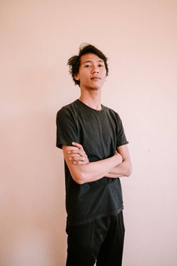 Kollarını kavuşturan Güneydoğu Asyalı bir adam, özgüven ve özgüven sergiliyor, portre, iş ve yaşam tarzı projeleri için mükemmel.