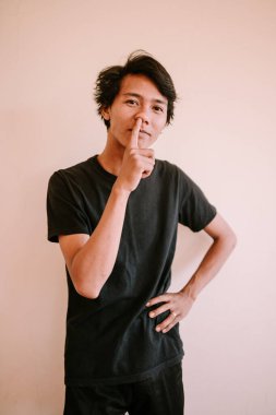 Burnunu karıştıran Güneydoğu Asyalı bir adam, samimi bir kişisel alışkanlık anı yakalıyor, yaşam tarzı, mizah anlayışı ve günlük yaşam projeleri için mükemmel.