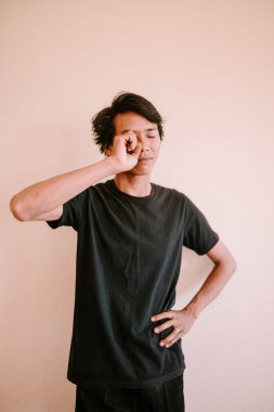 Gözüne bir şey kaçtığında irkilen Güneydoğu Asyalı bir adam, bir rahatsızlık veya sinir anını yakalıyor, sağlık, yaşam tarzı ve duygusal projeler için mükemmel..