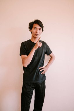 Güneydoğu Asyalı bir adam parmağıyla işaret ediyor, dikkat çekiyor veya yönlendiriyor, eğitici, iş ve portre projeleri için mükemmel..