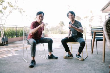 İki Güneydoğu Asyalı sohbet ediyor, bir anı yakalıyorlar