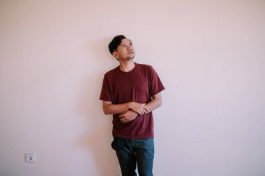 Güneydoğu Asyalı bir adam yukarı bakar, merakı ya da düşünceyi yansıtır. Arzu, merak ve içgözlem temaları için mükemmel.