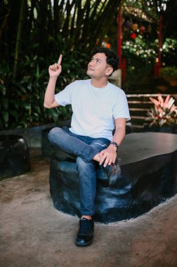 Güneydoğu Asyalı bir adam heyecanla yanıp tutuşuyor ve aklına bir fikir geldiğini işaret ediyor. Yaratıcılık, ilham ve problem çözme temaları için mükemmel.