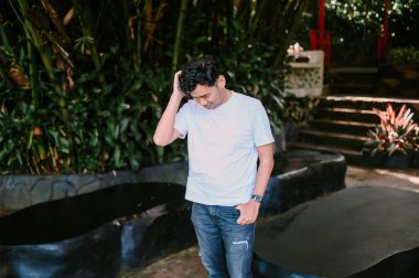 Güneydoğu Asyalı bir adam kafasını karışıklıkla kaşıyarak belirsizlik ve şaşkınlığı ifade ediyor. Problem çözme, kararsızlık ve insani duygular için mükemmel bir tema..