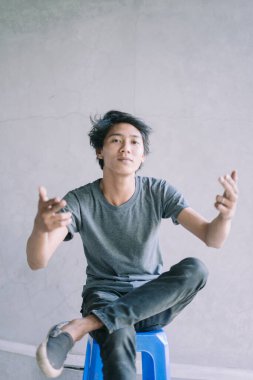 Neşeli bir ifade sergileyen Güneydoğu Asyalı bir adam, eğlence ve mutluluk anı yakalıyor, yaşam tarzı, portre ve neşeli projeler için mükemmel..