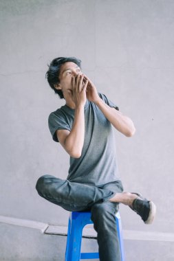 İki eliyle ağzını kapayan Güneydoğu Asyalı bir adam, bir anlık şaşkınlık ya da tereddüt, duygusal, portre ve yaşam tarzı projeleri için mükemmel.