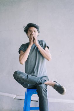 İki eliyle ağzını kapayan Güneydoğu Asyalı bir adam, bir anlık şaşkınlık ya da tereddüt, duygusal, portre ve yaşam tarzı projeleri için mükemmel.