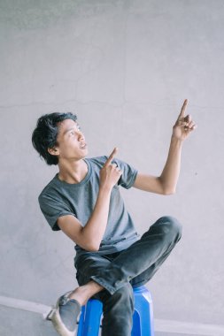 Neşeli bir ifade sergileyen Güneydoğu Asyalı bir adam, eğlence ve mutluluk anı yakalıyor, yaşam tarzı, portre ve neşeli projeler için mükemmel..