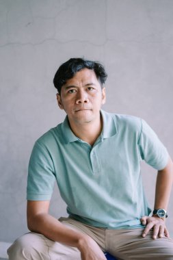 Tatlı bir ifadeyle Güneydoğu Asyalı bir adam, ileriye bakıyor, sakin ve çekici bir anı yakalıyor, portre, yaşam tarzı ve duygusal projeler için mükemmel.