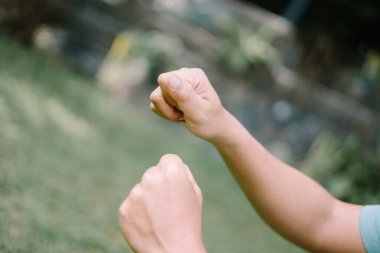 Yumruğunu sıkıca kavrayarak dövüşmeye hazır, gücünü ve azmini aktaran, eylem, çatışma ve dramatik projeler için mükemmel bir yumruk..